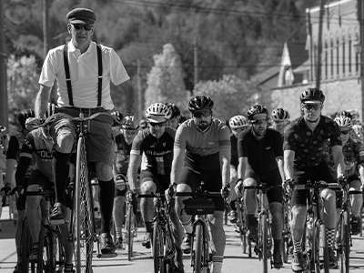 Creemore springs turas mor, Vintage kit is encourage, man in suspenders cycling on a pennyfarthing above modern racers