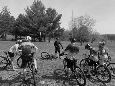 Group of riders with their backs to the camera focusing on instructor in the middle