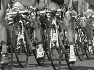 Close up on front tires of a pack of road cyclists racing