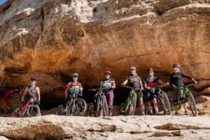 project rad riders line up inside a cave opening