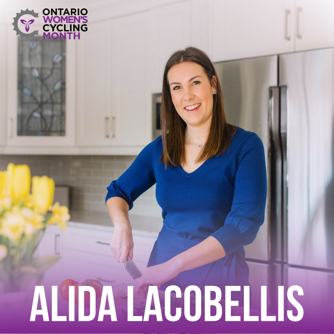 Alida Lacobellis smiling in her kitchen posing with a kitchen knife and cutting board