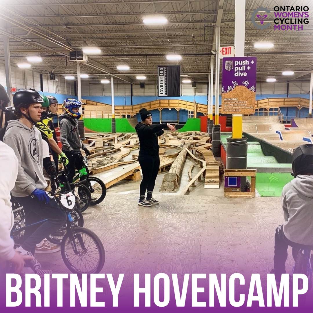 woman standing on wooden indoor ramp directing her campers