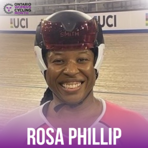 Woman smiling in facing the camera from the shoulders up wearing a time trial cycling helmet with the velodrome track in the background, text reads Rosa Phillip