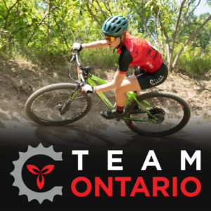 Female rider banking a dirt turn on Mountain Bike wearing Team Ontario Kit on a
